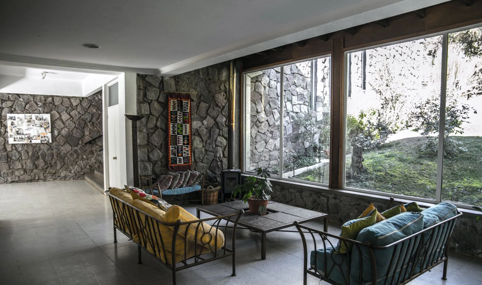Salón interior con muros de piedra y estufa a leña
